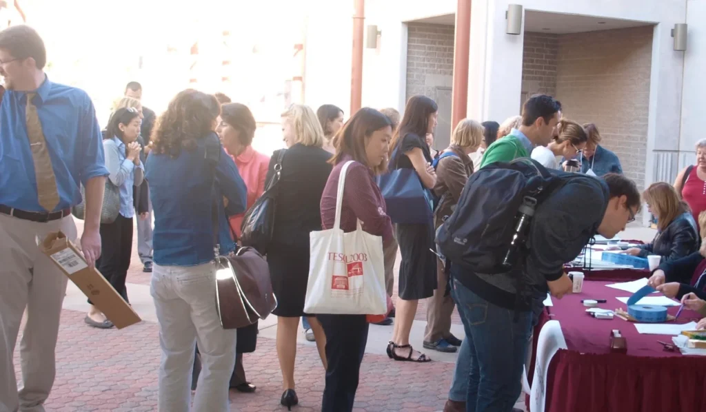 People registering at an outdoor event table.