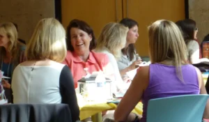Women talking and laughing at a table.