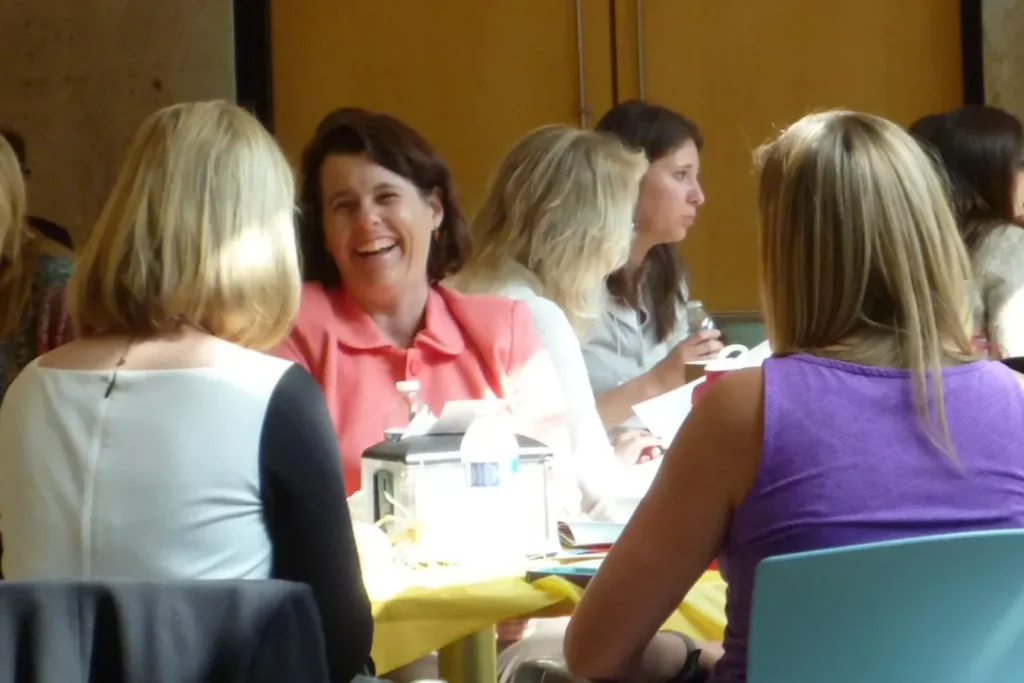 Women talking and laughing at a table.