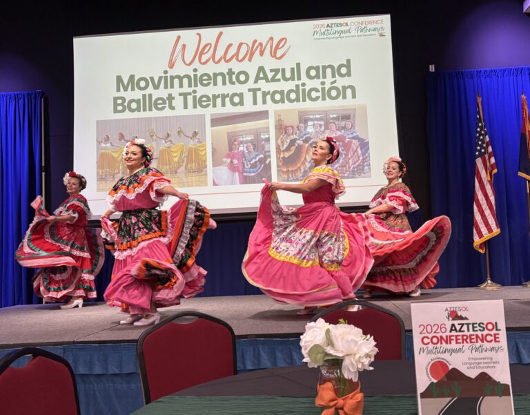 Four women dancing in traditional Mexican dresses