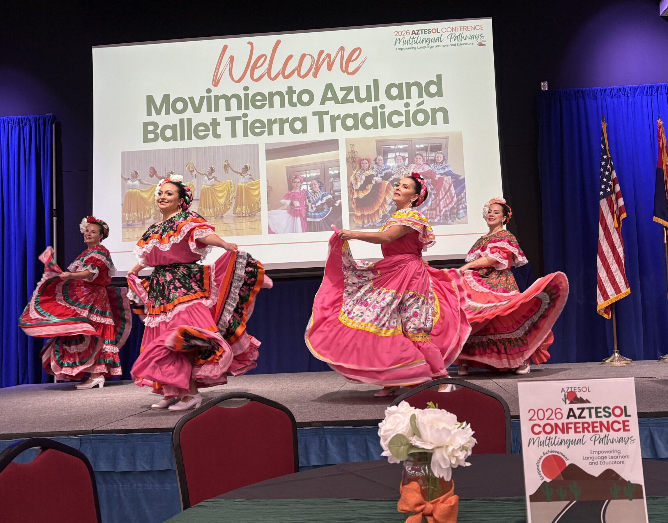 Four women dancing in traditional Mexican dresses