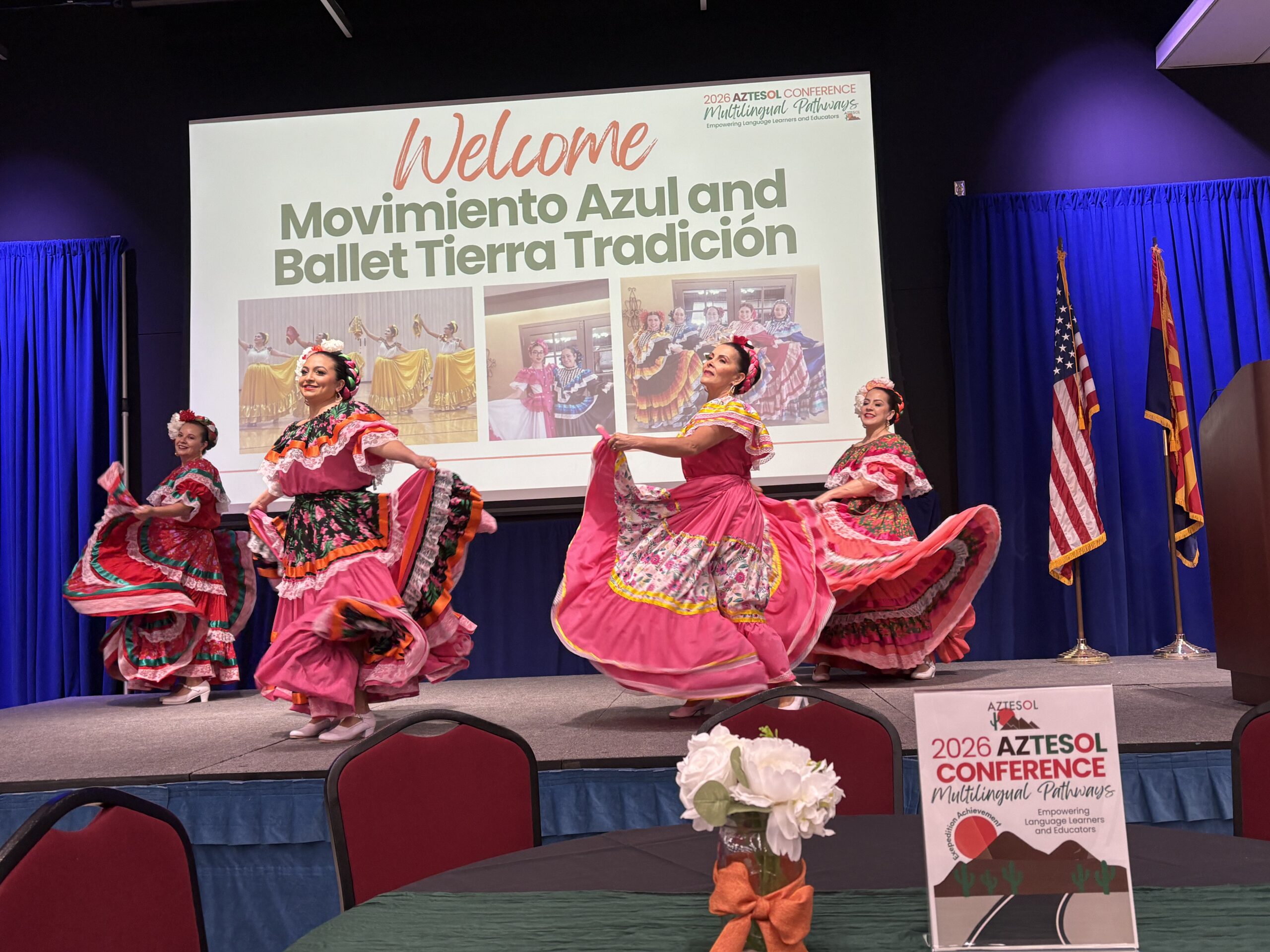 Four women dancing in traditional Mexican dresses