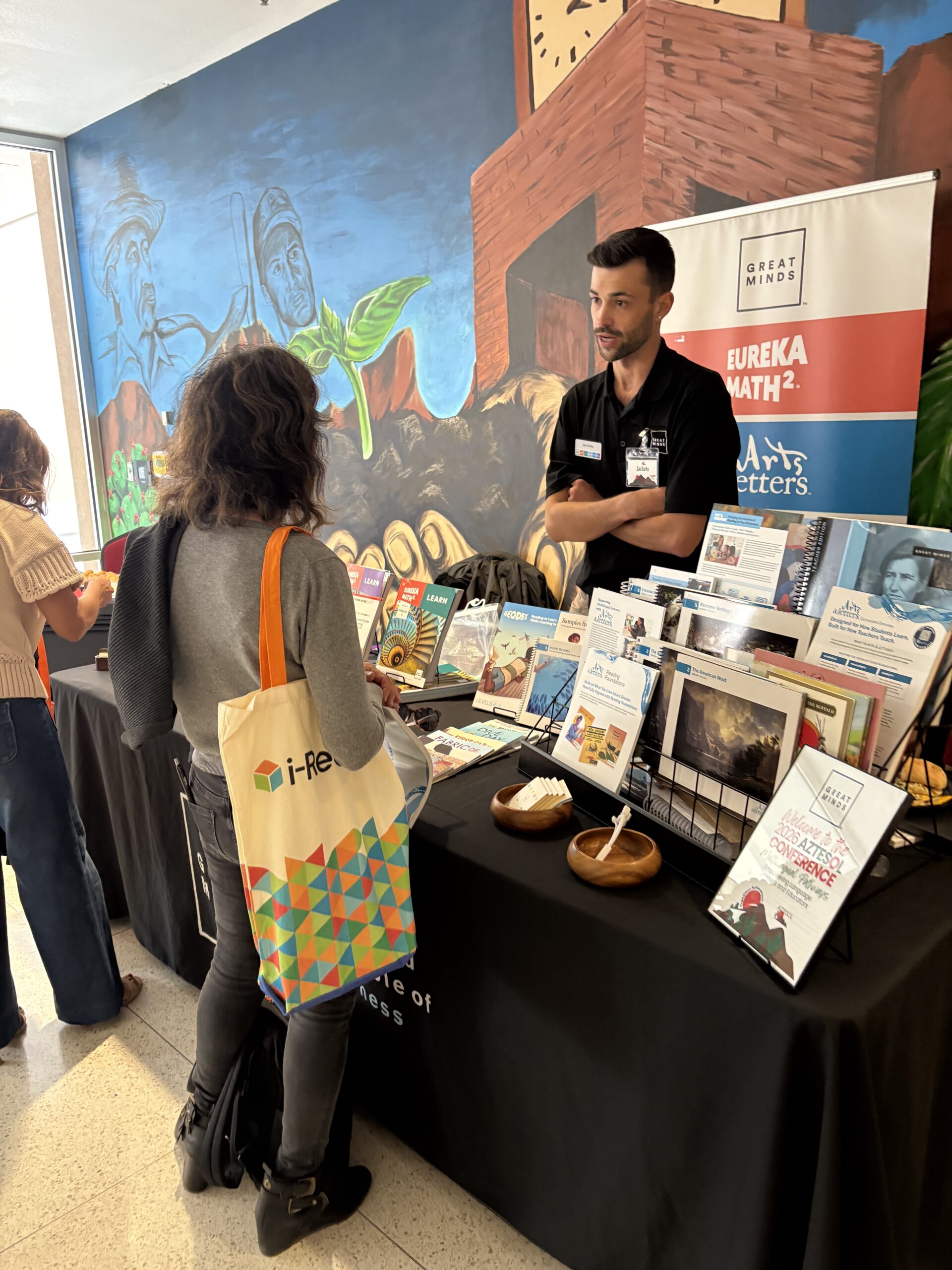 Education vendor standing at table and sharing materials with guest