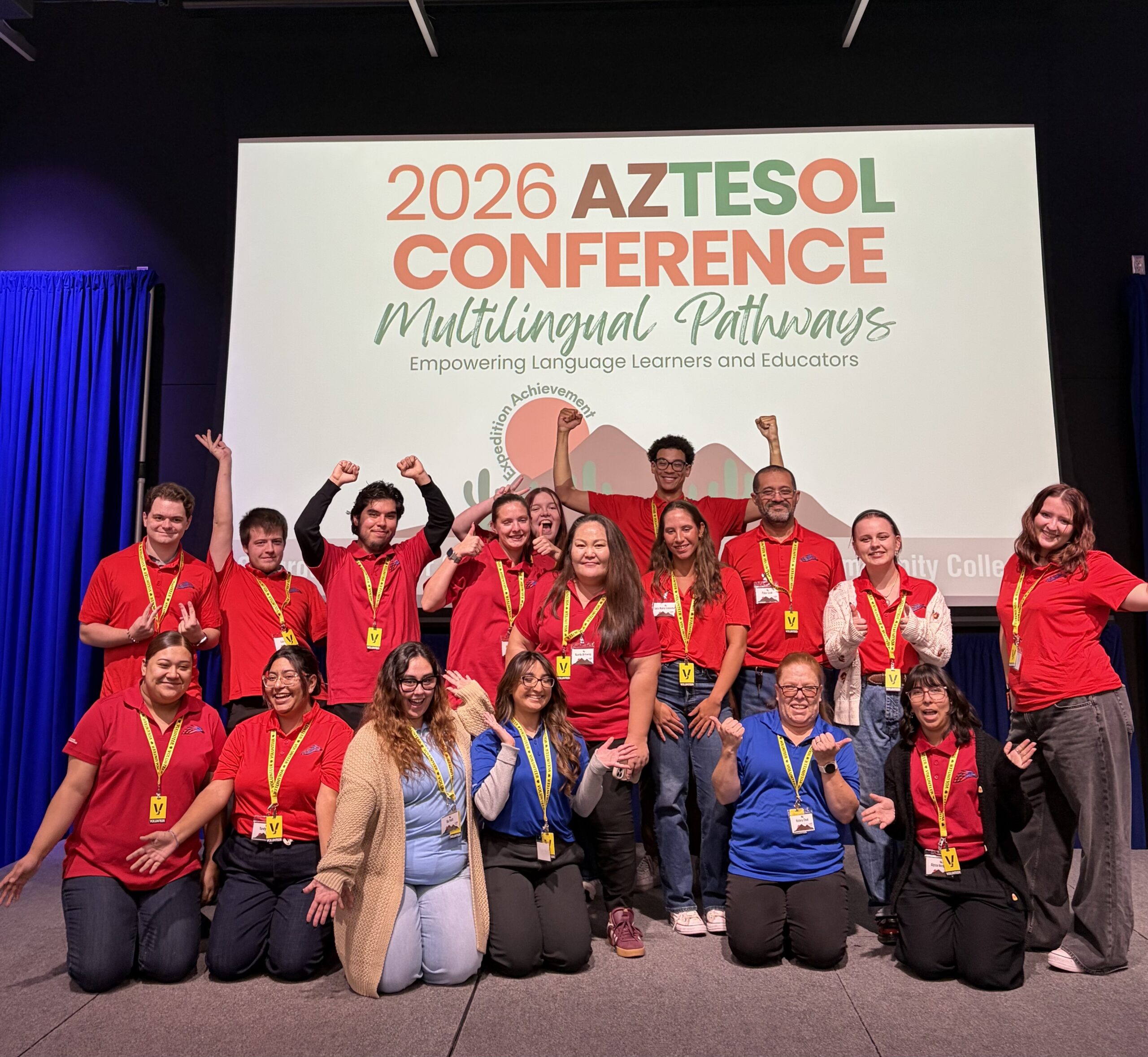 Group of volunteers wearing red shirts on a stage
