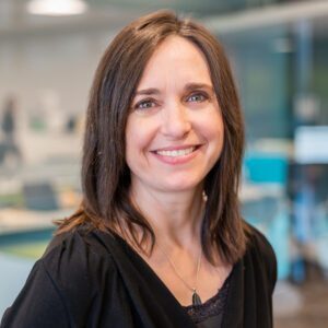 Smiling woman in a professional office setting.
